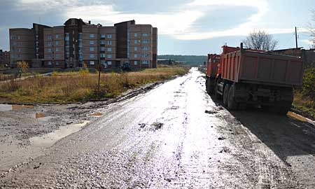 КамАЗы с песками СУМЗа проходят в считанных метрах от жилых домов поселка Кирзавода