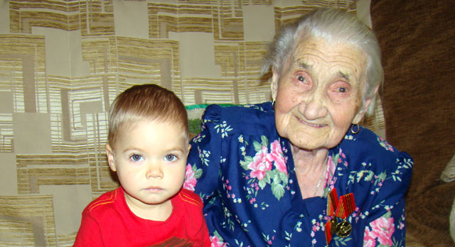 Правнуку Диме нет еще и двух лет, он с удовольствием показывает прабабушке Лизе свои любимые игрушечные машинки.