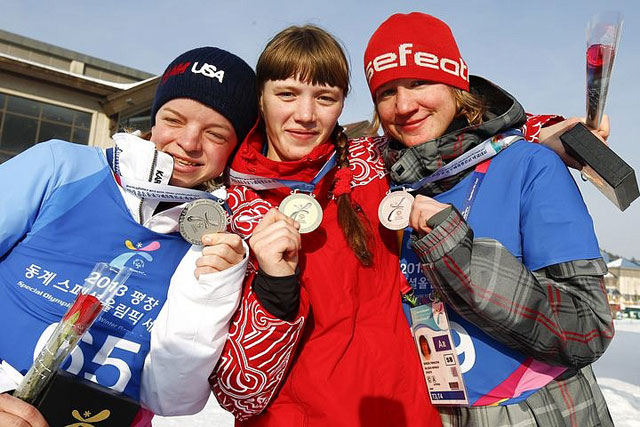 Елена Сагалаева (в центре) 31 января завоевала первую золотую медаль Всемирных зимних игр Специальной Олимпиады в Южной Корее. Слева спортсменка из США Дайана Шильц, справа — Дениза Трмалова из Чехии.