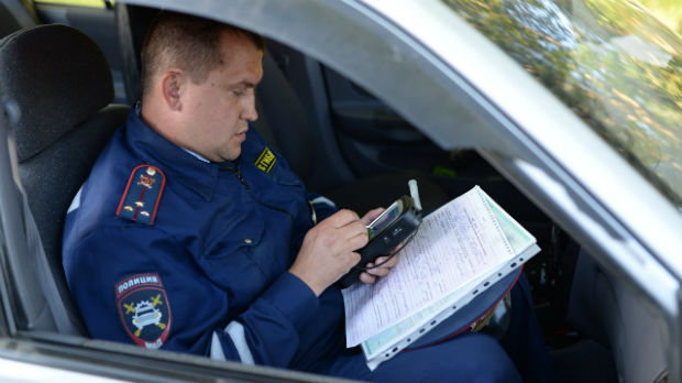 Сергей Панфилов, инспектор ДПС ревдинской ГИБДД, составляет административный протокол за езду в нетрезвом виде. 